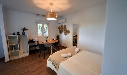 Un dormitorio con una cama y una mesa. en Apartamentos Sierra de Las Nieves en Ronda