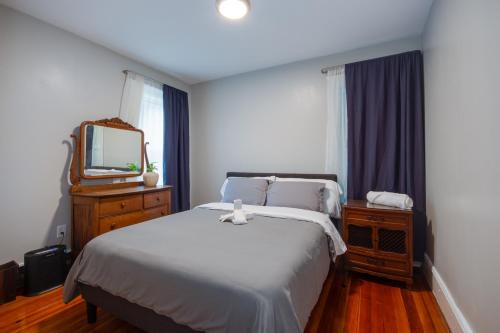 sypialnia z białym łóżkiem i lustrem w obiekcie Boston Queen Bedroom w mieście Boston
