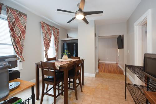 a dining room with a table and chairs and a ceiling fan at Boston Queen Bedroom in Boston