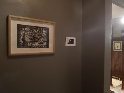 a wall with two pictures hanging on a wall at REQUELstore in Sungai Pelik