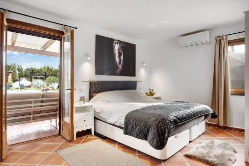 um quarto com uma cama e uma grande janela em Villalaluna lacasa em Vejer de la Frontera