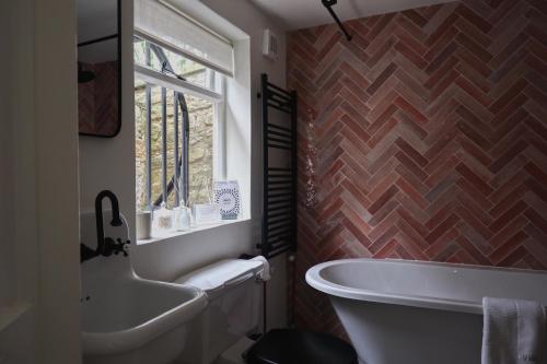 La salle de bains est pourvue d'une baignoire blanche et d'une fenêtre. dans l'établissement Charming Georgian Cottage with Private Sun Terrace, à Bath