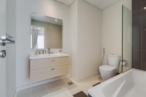 ein Badezimmer mit einem Waschbecken, einer Badewanne und einem WC in der Unterkunft Primestay - Damac Hills 2 Aster Villa 3 Bedroom in Dubai