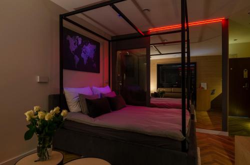 a bedroom with a canopy bed with a vase of flowers at LupoApartments z Klimatyzacją do wyboru z Jacuzzi Pole Dance Parking Dostęp na Kod in Łódź