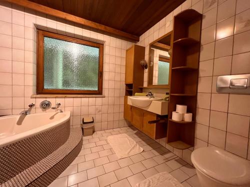 ツェル・アム・ツィラーにあるHaus Barbaraのバスルーム(バスタブ、洗面台、トイレ付)