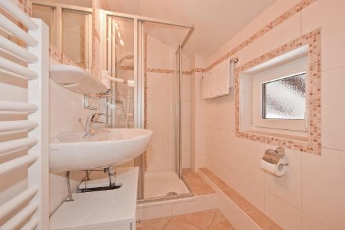uma casa de banho branca com um lavatório e um chuveiro em Ferienwohnungen Merzer em Mittenwald
