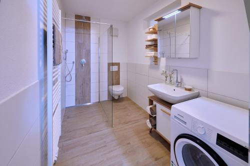 a bathroom with a sink and a washing machine at Ferienwohnung zwischen Burghausen und Salzburg in Tittmoning