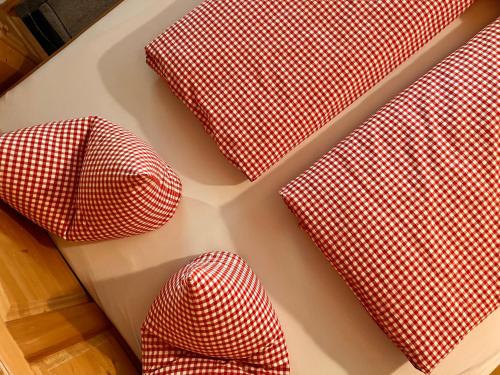 four red and white checkered pillows on a table at Schulhaus Tirol in Zell am Ziller