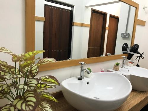 a bathroom with a white sink and a mirror at Ipoh Family Masjid Muhammadiah Evicharger 8pax SY15 in Ipoh