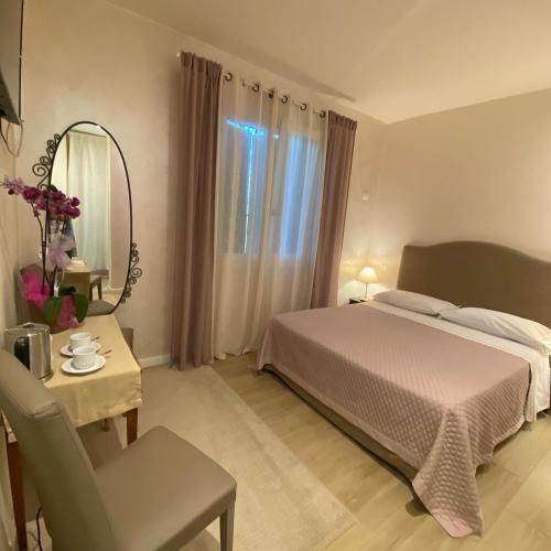 a bedroom with a bed and a table and a mirror at B&B Ai Filari in Baone