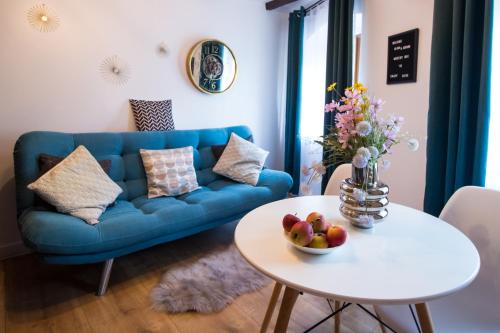 a living room with a blue couch and a table at Mystery Box Apartament incantator in Sibiu