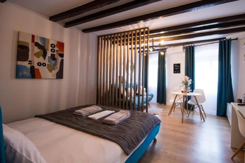 a bedroom with a large bed and a dining room at Mystery Box Apartament incantator in Sibiu