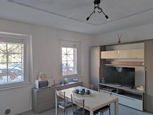 a living room with a table and a tv at Grey House Pavia con Box Privato in Pavia