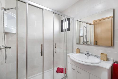a white bathroom with a sink and a shower at Apartamento La Estrella I in Playa Honda