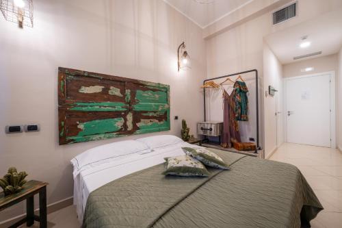 a bedroom with a bed and a painting on the wall at Love & Fama Hotel in Sabaudia