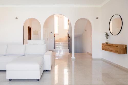 a living room with white furniture and a mirror at Modern Villa with heated pool and mountain views in Arona