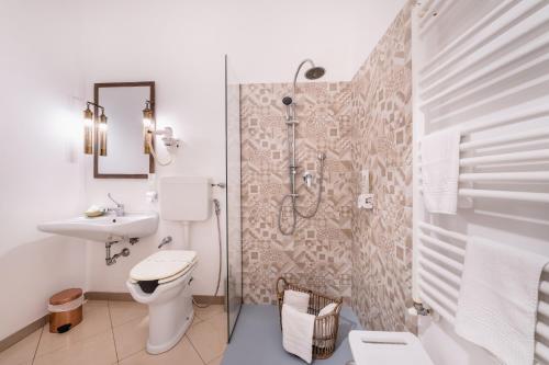 a bathroom with a shower and a toilet and a sink at Love & Fama Hotel in Sabaudia
