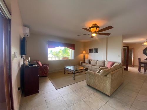 a living room with a couch and a ceiling fan at Los Porticos in Placencia Village
