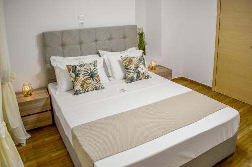 sypialnia z dużym białym łóżkiem z poduszkami w obiekcie La Maison Plakes 3 BDR Apt w mieście Skiatos