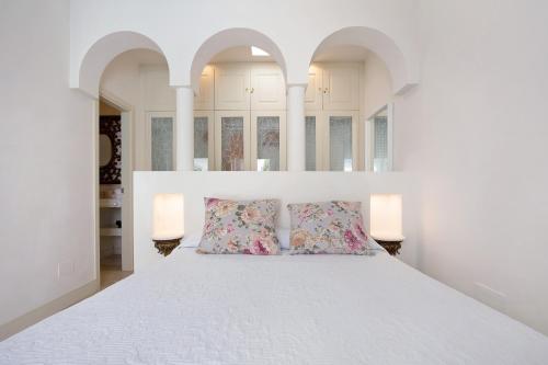 a white bedroom with a large bed with two pillows at Villa 87 in Corralejo