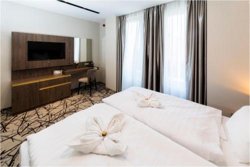 pokój hotelowy z 2 łóżkami z kwiatami w obiekcie Hotel Szatmári & Étterem Jászberény w mieście Jászberény