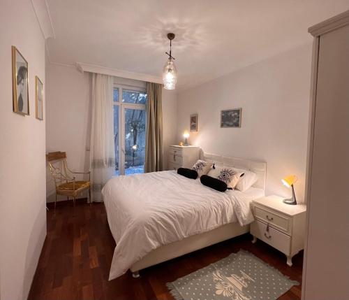 a bedroom with a white bed and a window at Secure, Spacious, and Eclectic 1 to 3 Bedroom Apartments w Pool, Garden, Private Parking, Tennis Basketball Football Courts and Concierge close to Istinye Park, Turkish Tennis Federation, and Acibadem Maslak in Istanbul