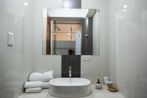 a white bathroom with a sink and a mirror at Hotel Las Quenas in Cusco