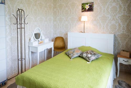 um quarto com uma cama verde e um espelho em Muru Guesthouse em Kuressaare
