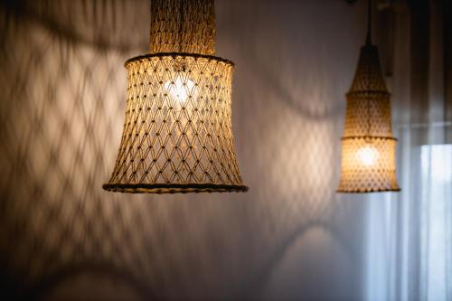 two lights hanging on a wall next to a window at Love & Fama Hotel in Sabaudia