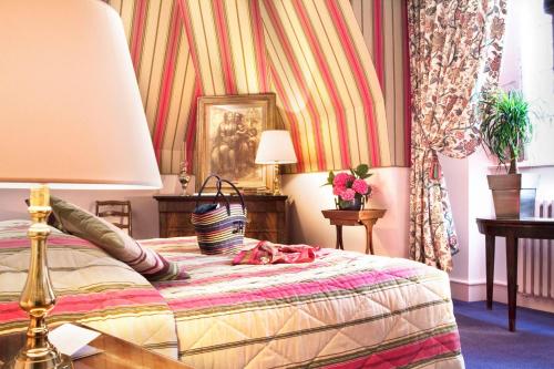 a bedroom with a bed with a lamp and flowers at Château de Noizay - ChâteauZen in Noizay
