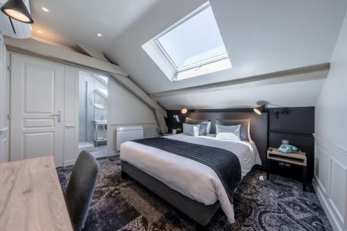 a bedroom with a large bed and a skylight at Allobroges Park Hôtel in Annecy