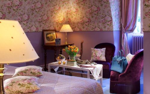 a bedroom with a bed and two chairs and a table at Château de Noizay - ChâteauZen in Noizay
