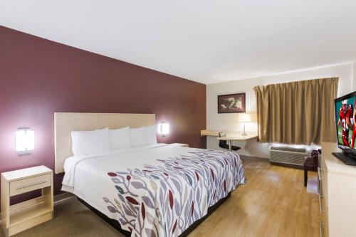 a hotel room with a bed and a flat screen tv at Red Roof Inn London I-75 in London