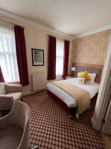 a hotel room with a bed and a chair at Haley's Hotel in Leeds