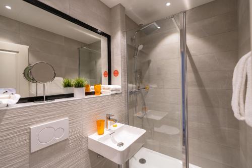 a bathroom with a sink and a shower at Allobroges Park H&ocirc;tel in Annecy