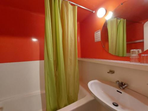 La salle de bains est pourvue d'un rideau de douche vert et d'un lavabo. dans l'établissement Studio 4 pers, skis aux pieds, proche commerces, animaux admis - FR-1-411-653, à Arc 1800