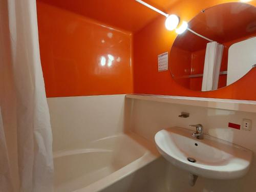 La salle de bains orange est pourvue d'un lavabo et d'un miroir. dans l'établissement Studio skis aux pieds proche commerces, Arc 1800, 4 pers - FR-1-411-54, à Arc 1800