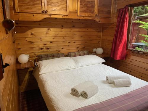 a bedroom with a bed with towels on it at Lurchers Cabin Aviemore in Aviemore
