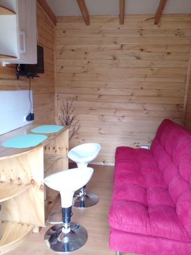 a living room with a red couch and a counter at Eco Cabañas Wanderlust in Puerto Puyuhuapi
