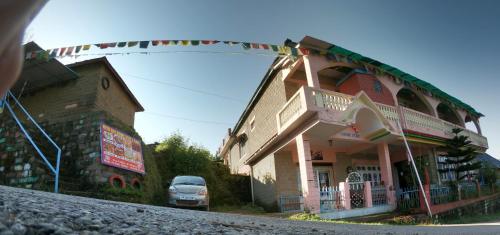 a car parked in front of a building at Ritu Raj Home Stay & Cafe in Malther