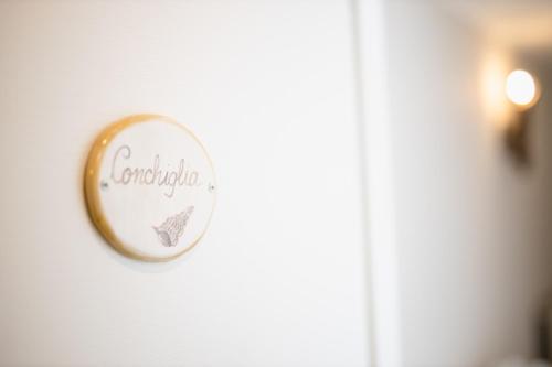 a round sign on a door with the word confederation at Love & Fama Hotel in Sabaudia
