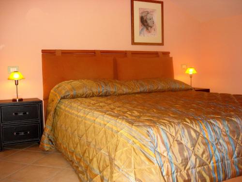 ポッツァッロにあるCase Sicule - Villa Sikeliaのベッドルーム1室(ベッド1台、テーブルにランプ2つ付)