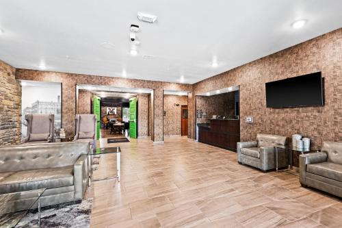 a lobby with chairs and a flat screen tv at Cobblestone Hotel & Suites - Superior Duluth in Superior