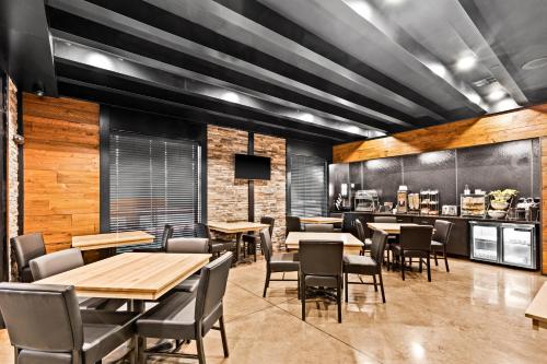 a restaurant with tables and chairs and a bar at Cobblestone Hotel & Suites - Superior Duluth in Superior
