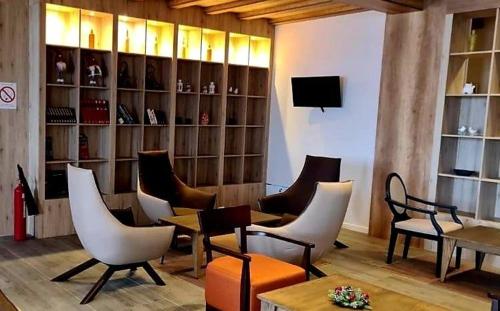 a living room with chairs and tables and a television at VS Apartman , Hotel Župa Kopaonik in Kopaonik