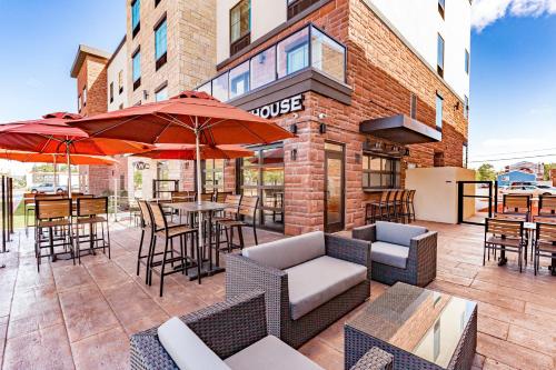 an outdoor patio with tables and chairs and umbrellas at Cobblestone Hotel & Suites - Superior Duluth in Superior