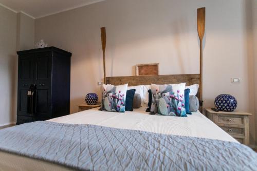 a bedroom with a large bed with pillows at Love & Fama Hotel in Sabaudia
