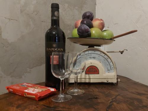 a bottle of wine and two wine glasses on a table at הבית החום יחידת אירוח לזוגות ומטיילים בערבה in Sappir