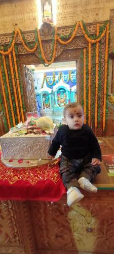 a baby sitting on a table in front of a mirror at Ritu Raj Home Stay & Cafe in Malther