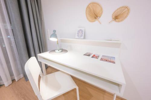 a white desk with a lamp and a chair at Luxury Suites Liechtenstein in Vienna